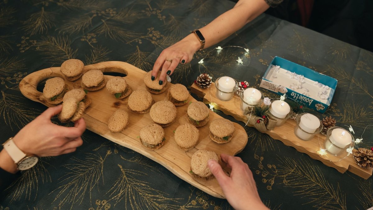 Convives se servant de mini-burgers partagés sur planche dans ambiance de fête